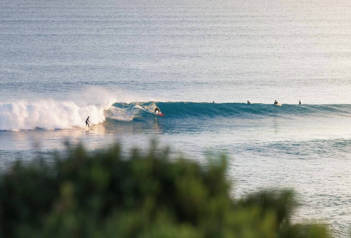 Cena de praia com surfistas e ondas.