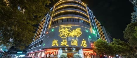 A hotel with a distinctive curved facade and illuminated signage.