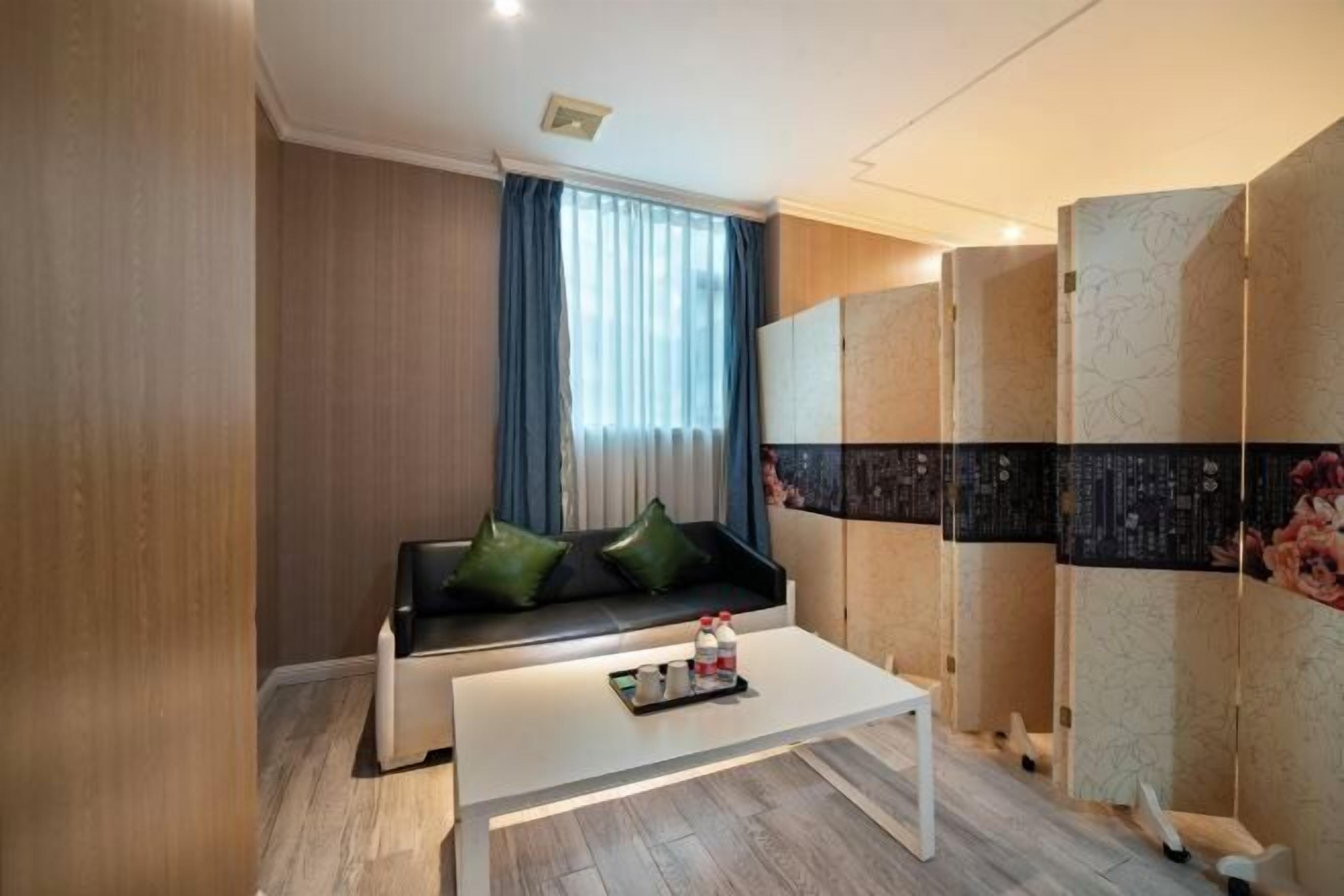 A modern room with a sofa, a coffee table, and a decorative wall panel.