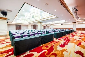 A conference room with rows of tables and chairs, a patterned carpet, and a large chandelier. - Guopeng International Hotel (Pingnan)