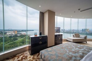 A modern bedroom with a large window, a bed, a dresser, and a sofa. - Guopeng International Hotel (Pingnan)
