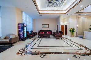 A hotel lobby with a reception desk, seating area, and a large chandelier. - Guopeng International Hotel (Pingnan)
