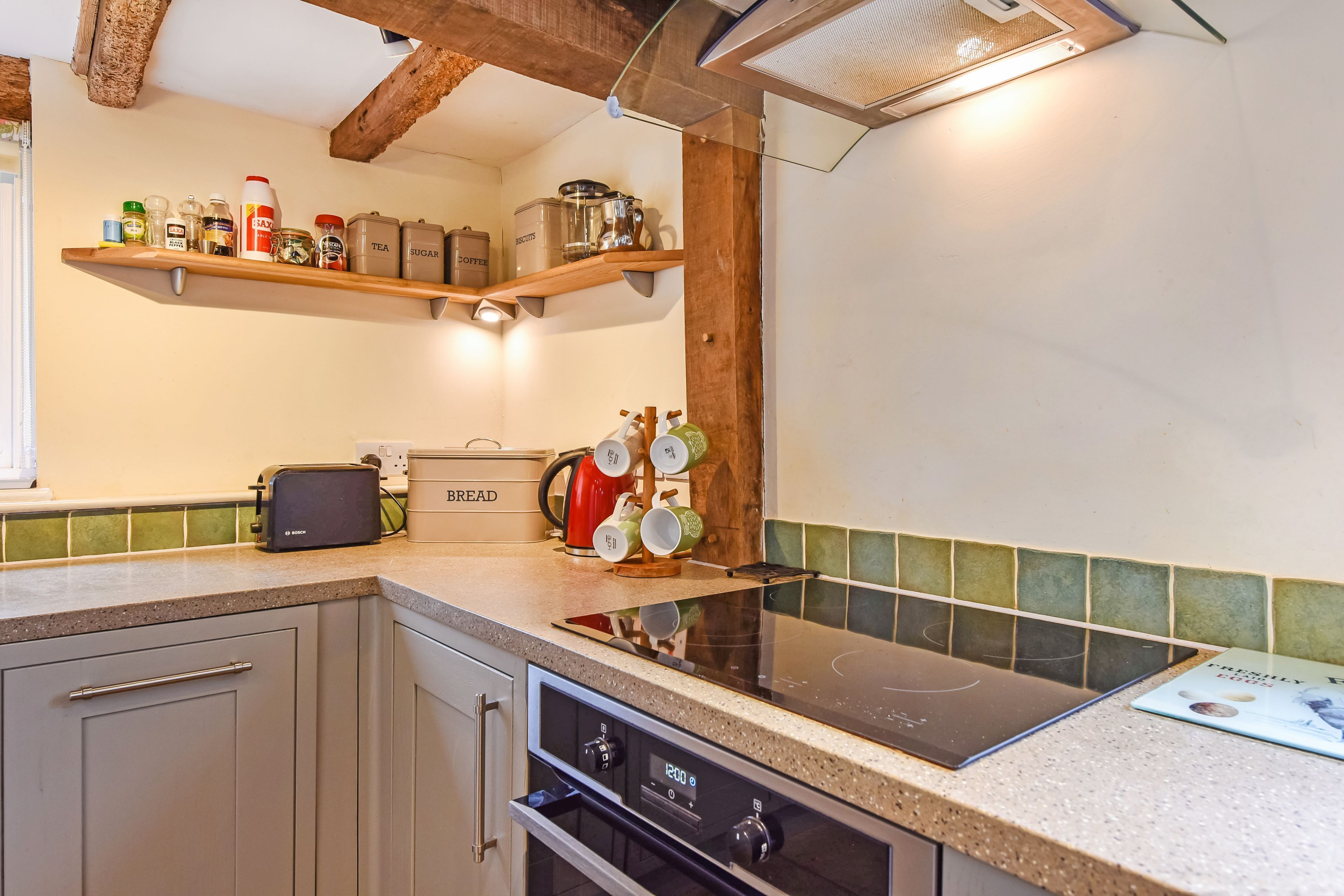 A kitchen with a Bosch toaster, a kettle, and a bread box on the counter.