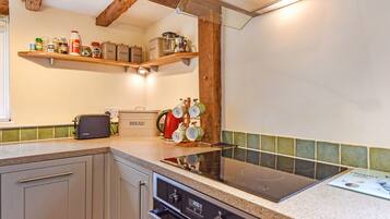 A kitchen with a Bosch toaster, a kettle, and a bread box on the counter.