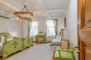 Classic bedroom with a large bed, wooden desk, and unique chandelier.