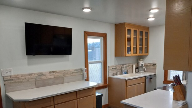 A modern kitchen with wooden cabinets, a built-in oven, and a window.