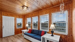 A wooden-paneled room with a sofa, two lamps, and a door. - 2877 - Carolina Dreamin - Oceanfront Duck Escape w/ Hot Tub & Views (Kitty Hawk)