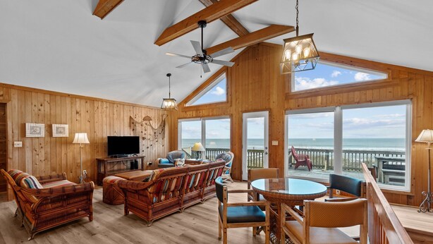 A wooden interior with a dining area, sofas, and a television. - 2877 - Carolina Dreamin - Oceanfront Duck Escape w/ Hot Tub & Views (Kitty Hawk)