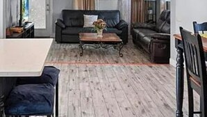 Un salon comprenant un canapé, une table basse et un coin repas avec des chaises.