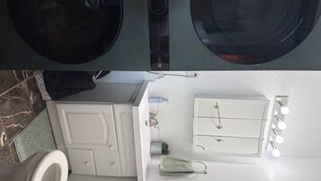 Een badkamer met toilet, wastafel, spiegel en handdoekhouder.