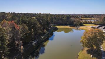 An aerial view of a lake surrounded by trees and a golf course.