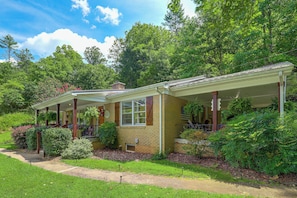 A two-story house with a covered porch, brick exterior, and surrounded by lush greenery. - Fire Pit & Game Room: Family Home in Marshall! (Marshall)