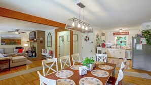 A spacious living room with a fireplace, a dining area with star-patterned placemats, and a kitchen with a 'Farm House' sign. - Fire Pit & Game Room: Family Home in Marshall! (Marshall)