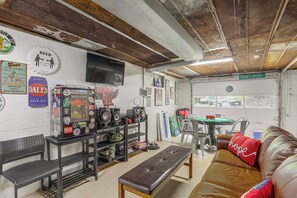 Une pièce équipée d’un téléviseur, de décorations murales, d’une table avec des chaises et d’un canapé.