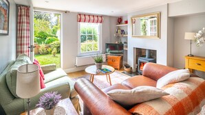 Una sala de estar acogedora con sofá, mesa de centro, chimenea y televisor.