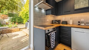 Una cocina moderna con armarios oscuros, una campana extractora de acero inoxidable y un lavavajillas.
