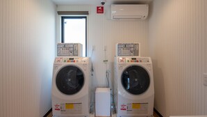 A laundry room with two front-loading washing machines and a dryer. - HOTEL R9 The Yard Asahishiro (Asahi)