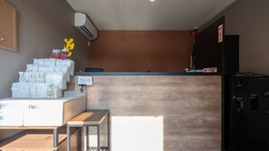 A reception area with a wooden counter, a computer, and a refrigerator. - HOTEL R9 The Yard Asahishiro (Asahi)