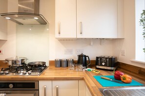 Fully equipped kitchen with gas stove, oven, and appliances.