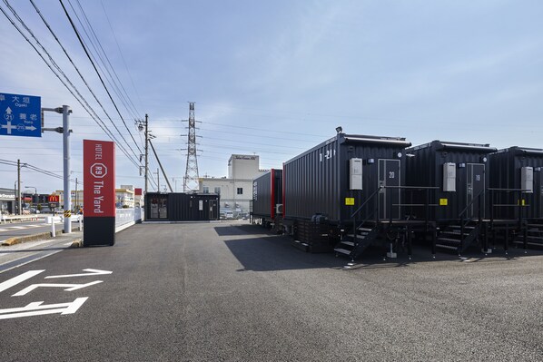 A railway station with multiple train cars, a clear sky, and a sign for Hotel 89. - HOTEL R9 The Yard Tarui (Tarui)