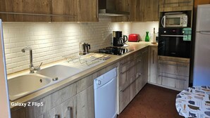 Eine moderne Küche mit Holzausstattung, einem Geschirrspüler von Bosch, einer Mikrowelle und einem Backofen von Bosch.