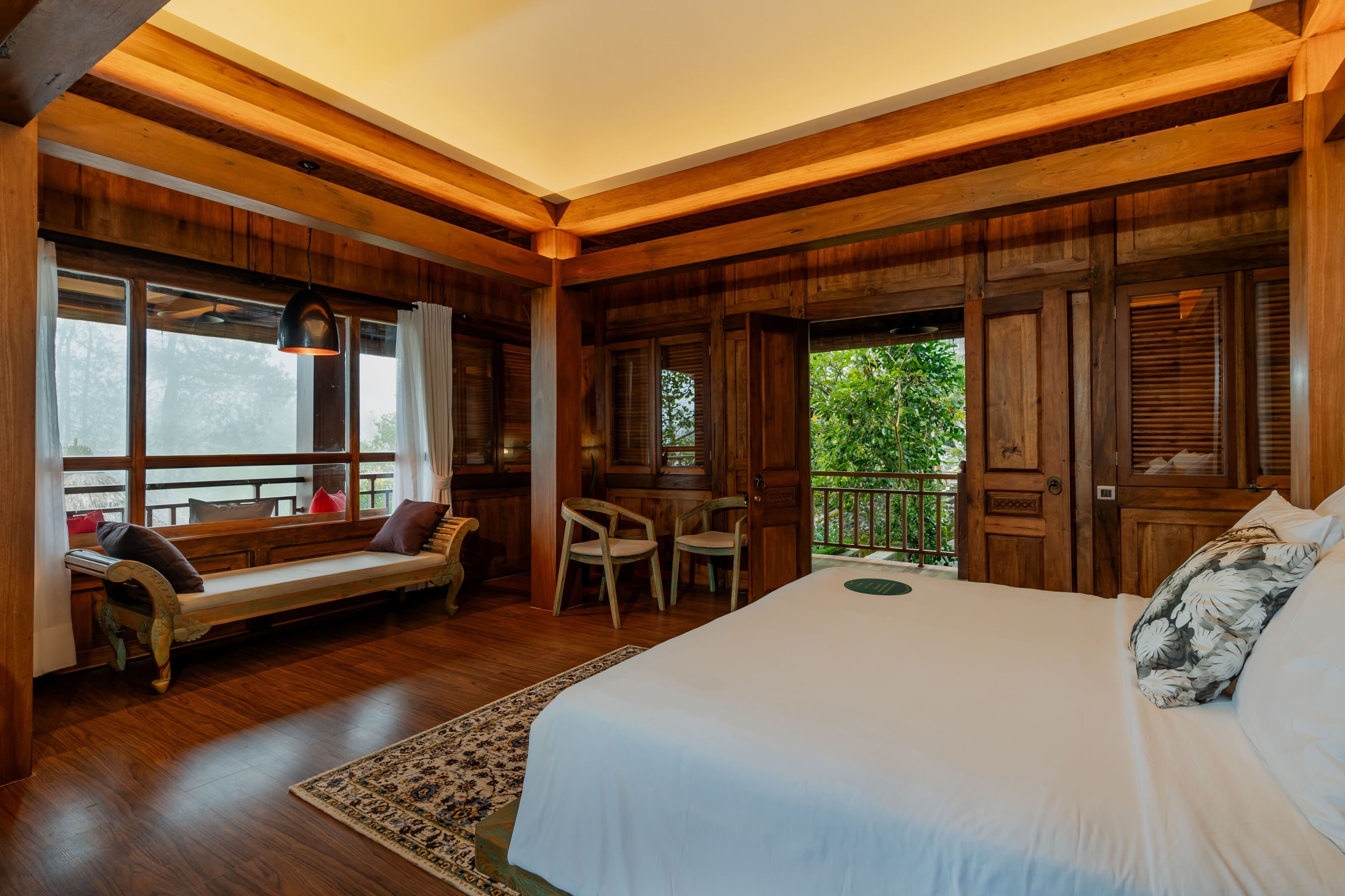 A wooden room with a bed, a bench, and a table.