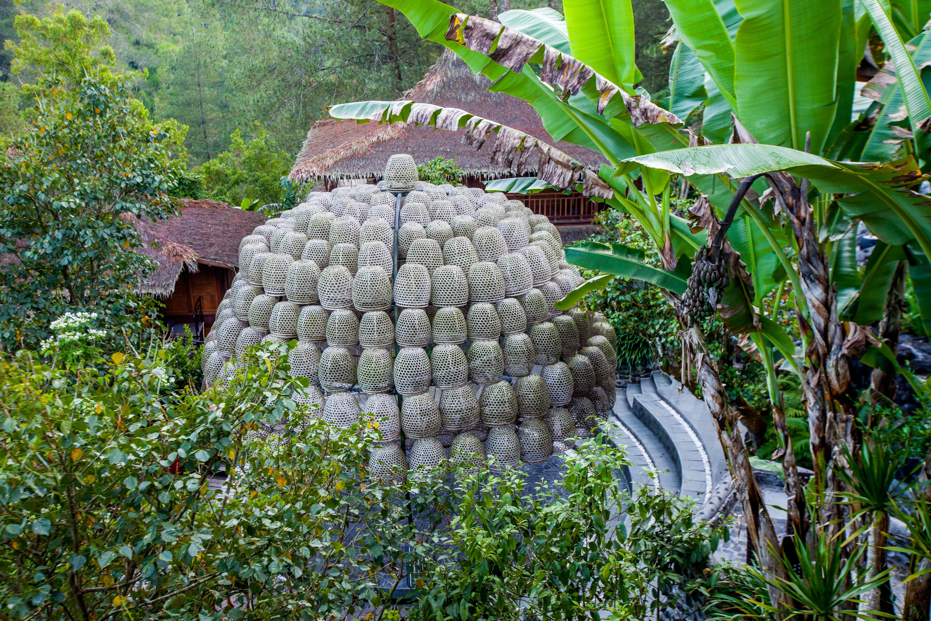 A traditional thatched-roof structure surrounded by lush greenery.