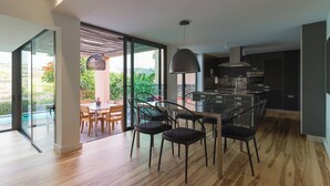 Uma cozinha moderna com área de jantar, janelas amplas e vista para o exterior.