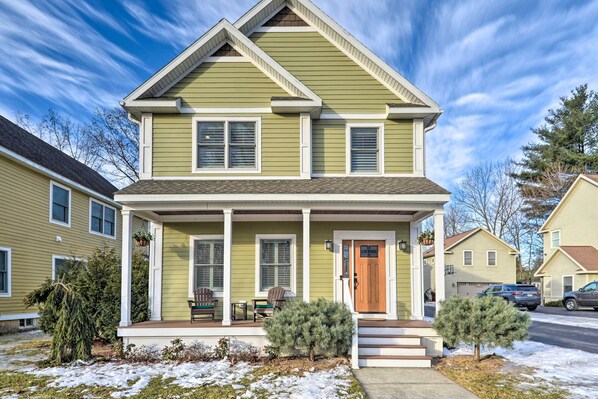 A two-story house with a front porch, a small front yard, and a garage. - Stunning House w/ Deck, Game Room & Home Gym! (Saratoga Springs)