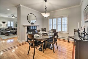 A dining area with a round table, chairs, and a chandelier. - Stunning House w/ Deck, Game Room & Home Gym! (Saratoga Springs)