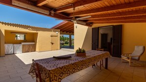 A covered patio area with a table set for dining, a chair, and a potted plant. - Holiday Home "Casa Vacanza Il Melograno" with 2 Private Terraces, A/C and Wi-Fi (Santa Maria del Focallo)