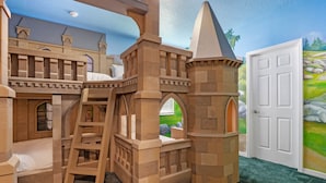 A castle-themed playroom with a bunk bed, ladder, and archways.