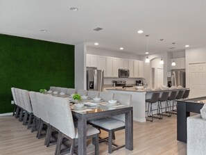 A modern kitchen with white cabinets, stainless steel appliances, and a central island with bar seating.