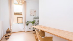 A minimalist room with a wooden bench, a potted plant, and a woven basket.