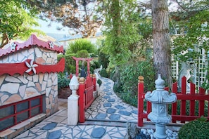 A stone pathway leading to a traditional building with a red gate and a stone lantern. - Holiday Home 'Au Printemps Japonais' with Mountain View, Garden, Balcony, A/C & Wi-Fi (Pierre-Châtel)
