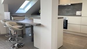 A modern kitchen with a skylight, a dining area with bar stools, and built-in appliances. - Apartment house "Charibi" a well-kept residential complex near the beach (Dahme)