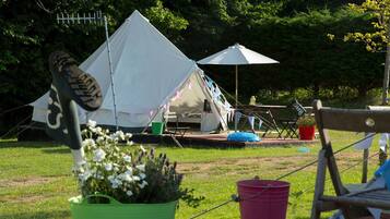 A campsite with a tent, a table, and a chair.
