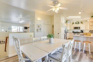 A spacious kitchen with white cabinetry, a central island with stools, and a ceiling fan. - Hike, Sled & Snowshoe! Family Retreat in Payson (Payson)