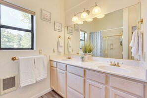 A bathroom with a large mirror, two sinks, and a window. There are towels hanging on the wall and a plant on the counter. - Hike, Sled & Snowshoe! Family Retreat in Payson (Payson)