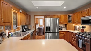 A modern kitchen with wooden cabinets, stainless steel appliances, and a central island. - One of a kind, Creek Front Lodge 3 floors, 2 kitchens, long distance views. (MARS HILL)