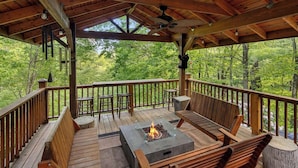 A covered outdoor deck with a fire pit, seating, and a view of a forest. - One of a kind, Creek Front Lodge 3 floors, 2 kitchens, long distance views. (MARS HILL)