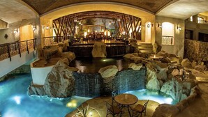 Ein Wellnessbereich mit Whirlpool, Sitzgelegenheiten und einer Bar.