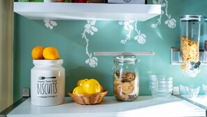 A kitchen counter with a jar of organic farm fresh biscuits, a basket of lemons, and a glass jar of cookies.