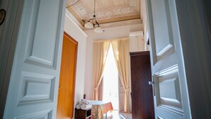 A hallway with a table set for dining, a chandelier, and a door leading to another room. - Double or Twin Room (Catania)