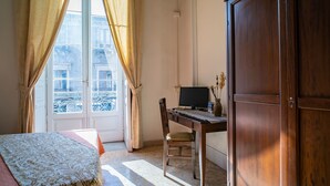 A bedroom with a bed, a desk with a computer, a chair, and a wardrobe. - Double or Twin Room (Catania)