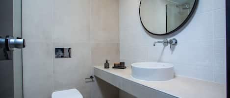 Une salle de bain moderne avec des toilettes, un lavabo et un miroir.