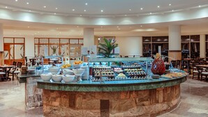 A buffet area with a marble counter, various food items, and seating arrangements in a spacious room. - SUNRISE Alma Bay Resort (Hurghada)