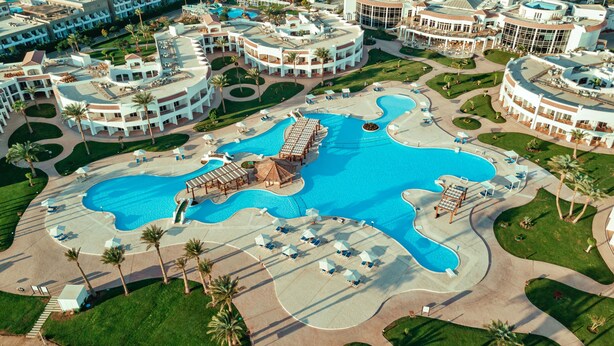 An aerial view of a resort with a large central pool, multiple connected pools, and a variety of outdoor seating areas. - SUNRISE Alma Bay Resort (Hurghada)