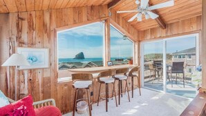 Un interno in legno con un'area bar, sgabelli da bar e vista sull'oceano.