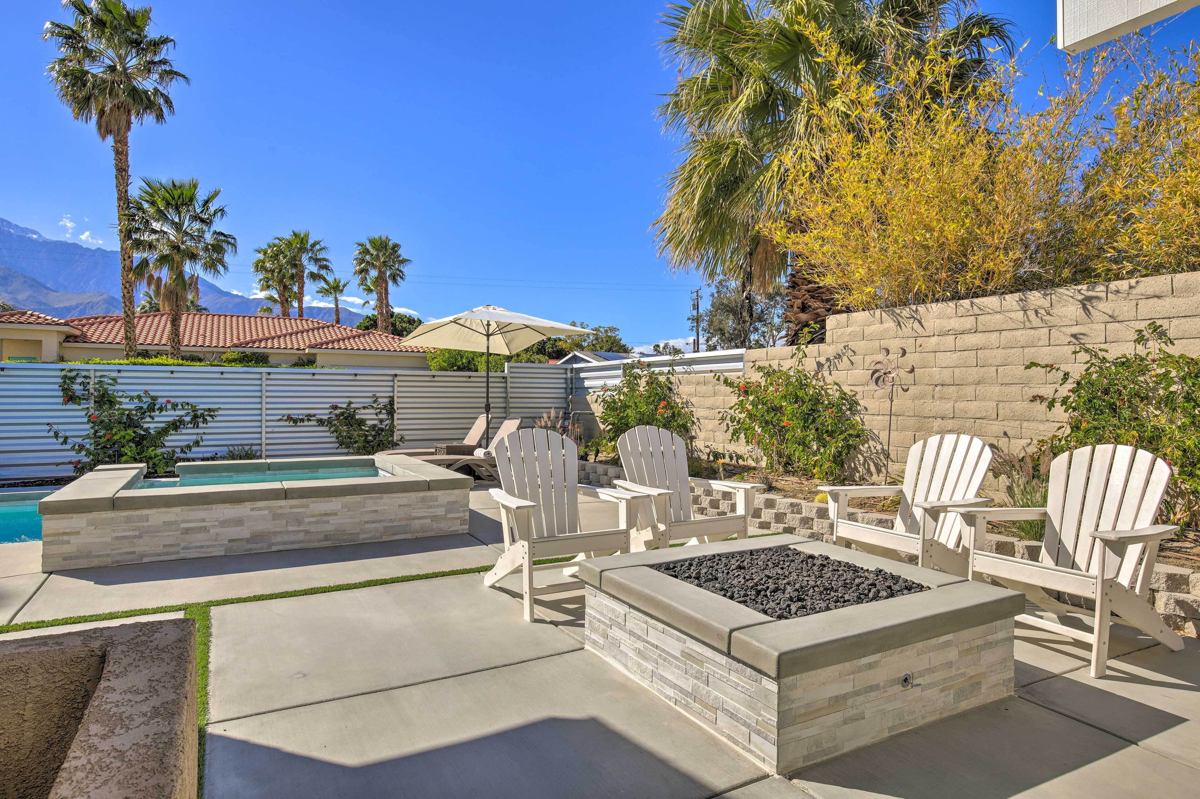 An outdoor patio with Adirondack chairs, a fire pit, and a swimming pool.